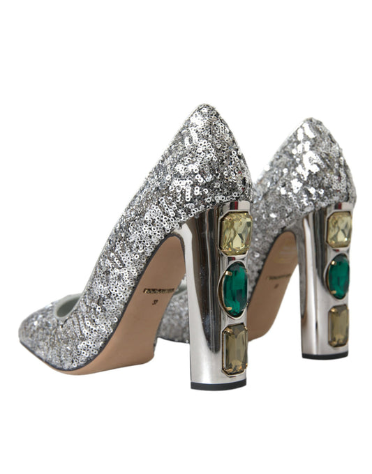 Pair of glittery silver high heel shoes with green stones on the heels