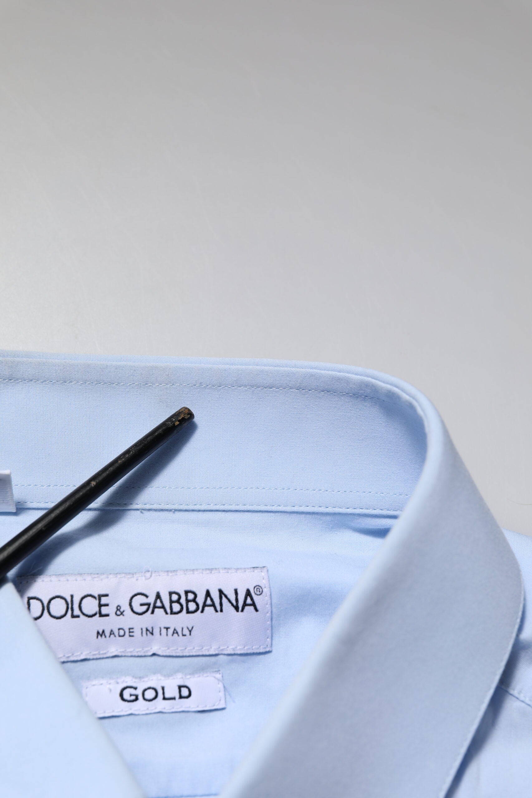 A blue dress shirt with a gold label from Dolce & Gabbana