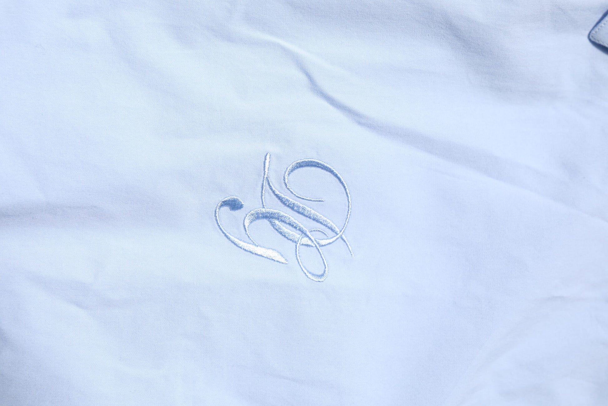 Gold embroidered logo on blue dress shirt