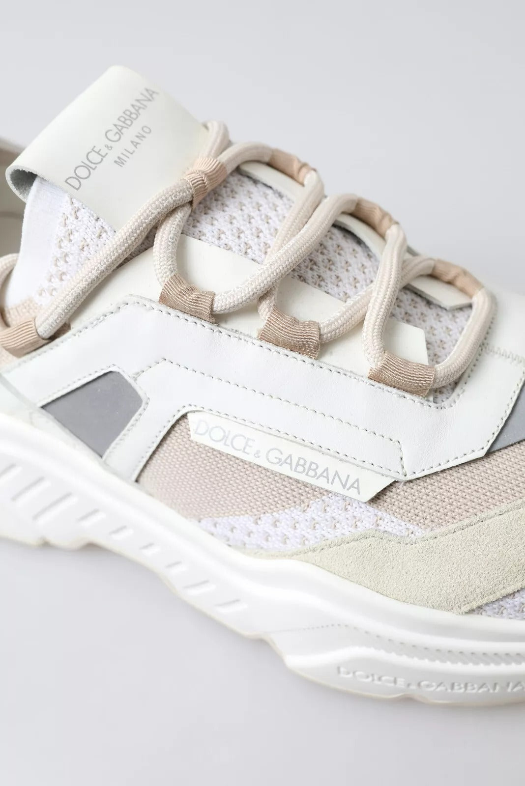 White sneaker with tan laces and a logo on the side