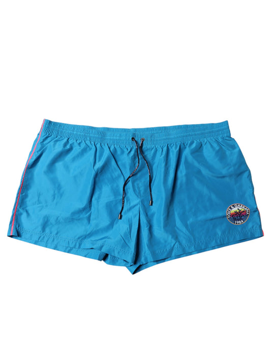 Blue swim shorts with red trim and logo