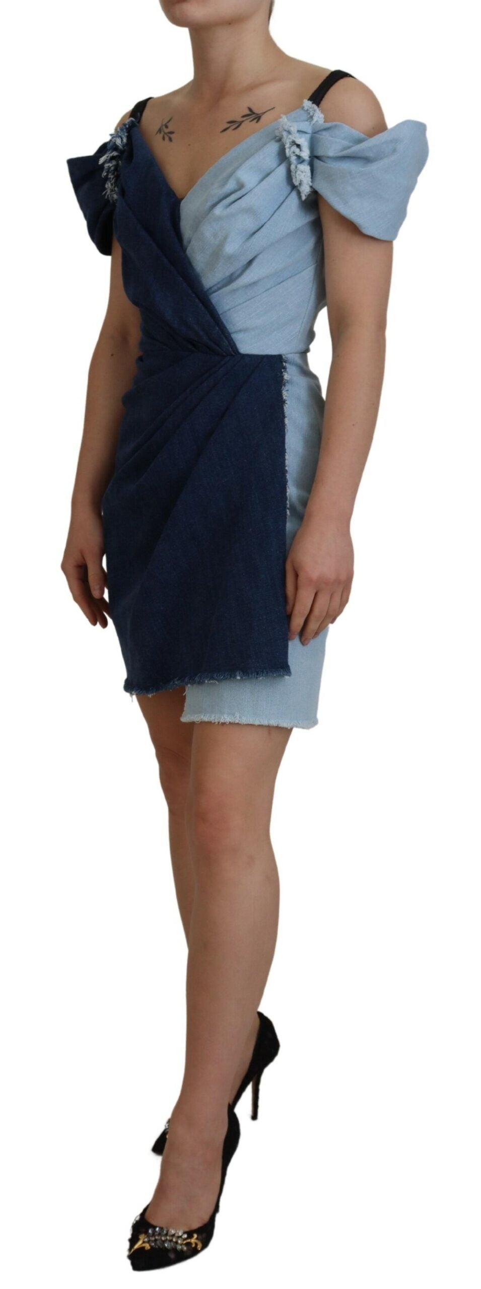 A woman wearing a blue denim dress with patchwork design and short sleeves