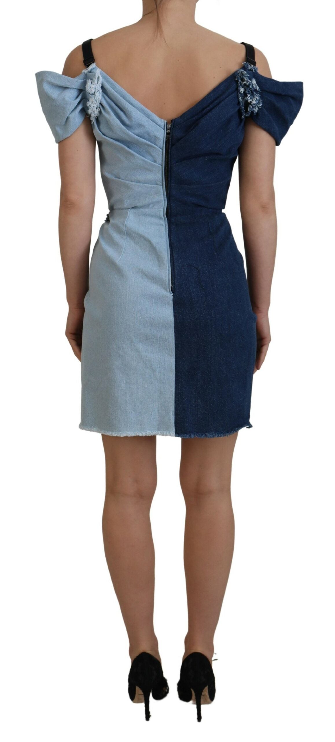 A blue denim dress with patchwork design and a high neckline, worn by a mannequin