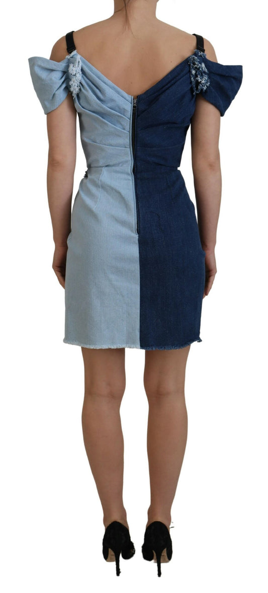 A blue denim dress with patchwork design and a high neckline, worn by a mannequin