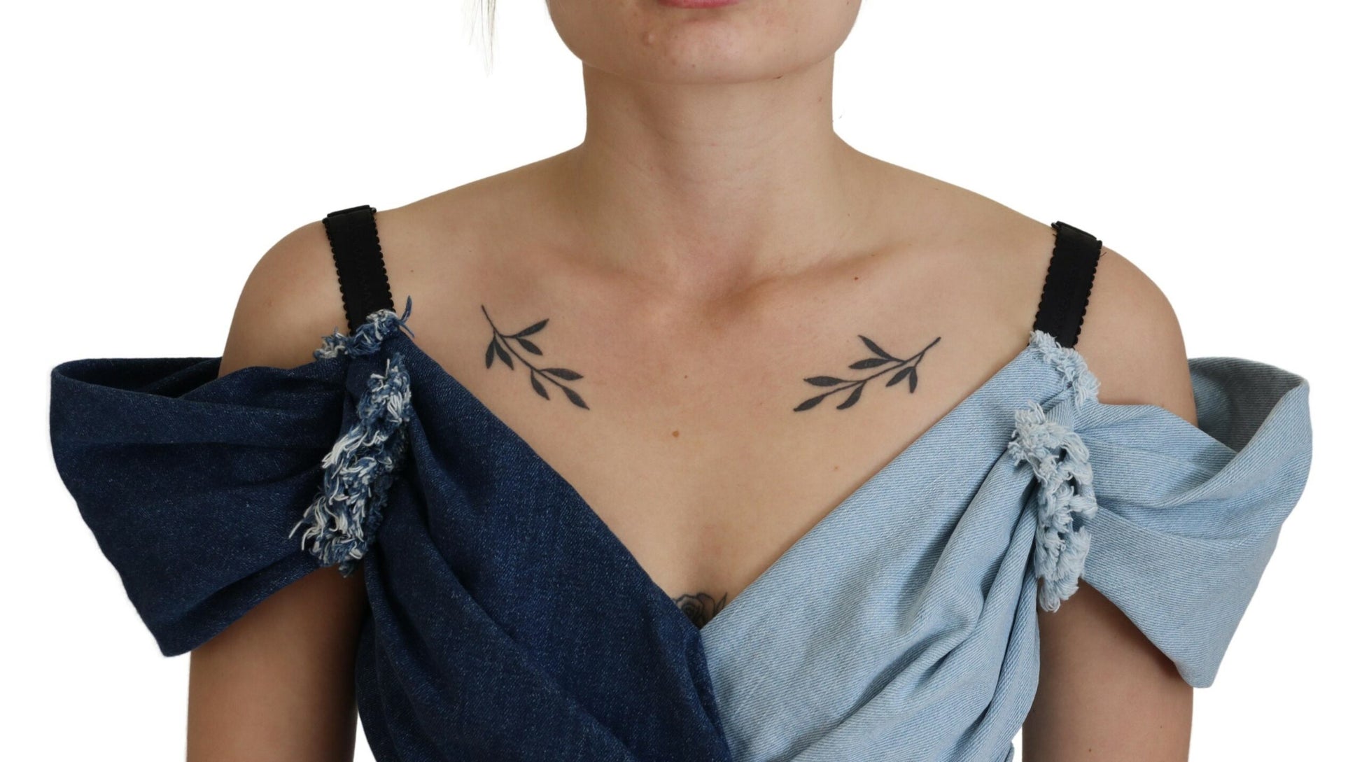 A blue denim dress with patchwork design and floral embellishments on the shoulders