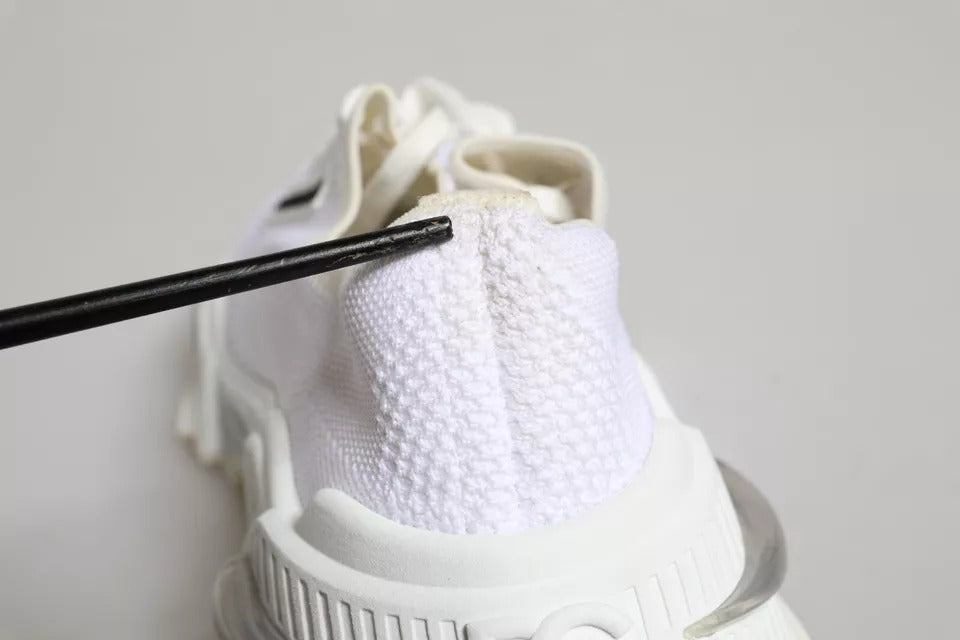 White sneakers with black laces, featuring a textured upper and a low top design
