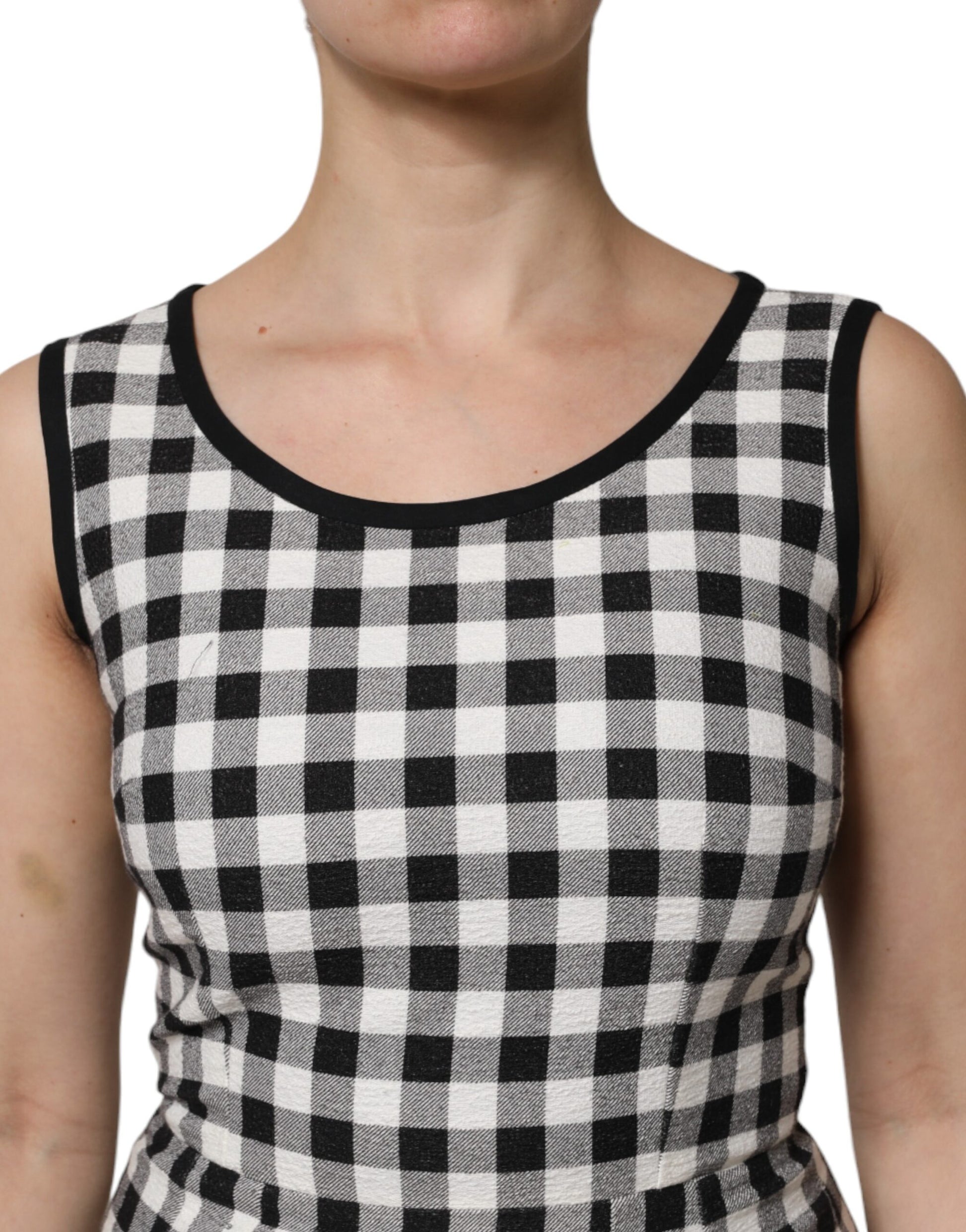 A sleeveless sheath dress with a black and white checkered pattern