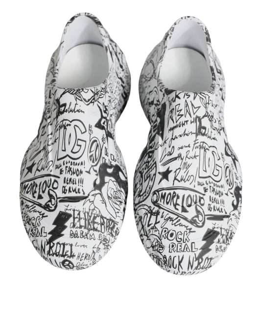 Pair of white slip on shoes with black writing and designs