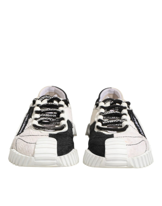 Pair of black and white leather sneakers with laces, featuring a textured design on the side