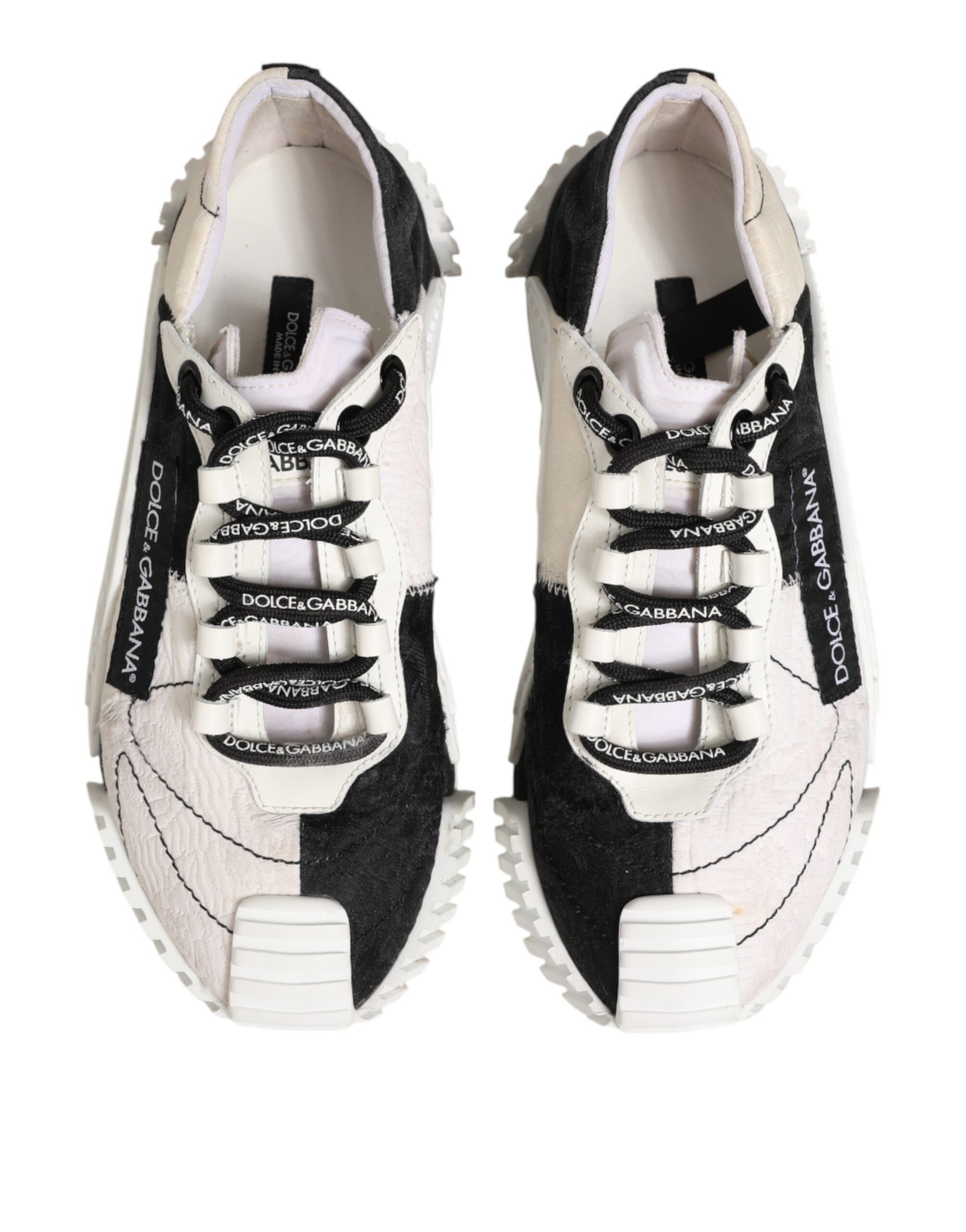 Pair of white black leather sneakers with laces and logo on side