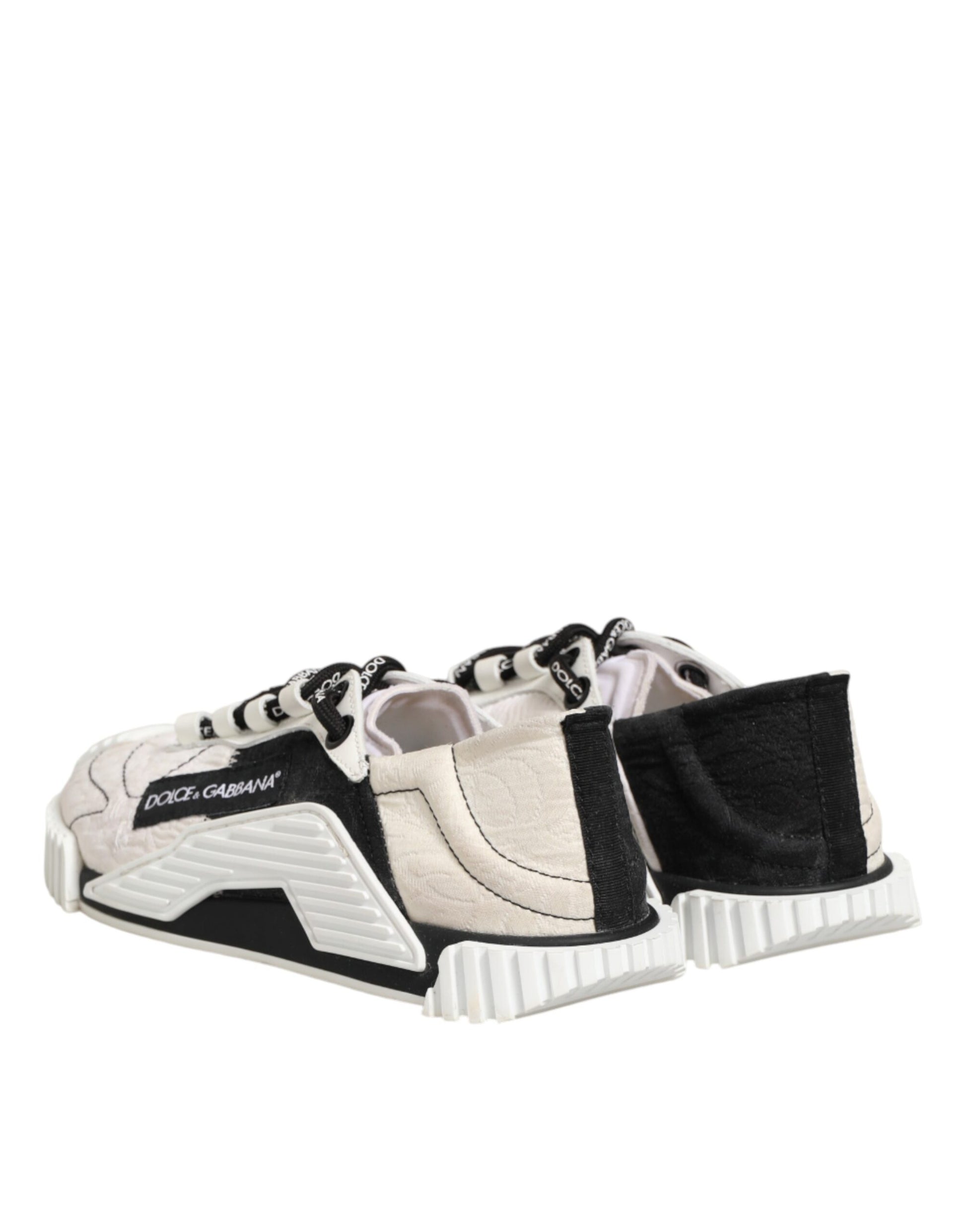 A pair of white black leather sneakers with a logo on the side, designed by Dolce & Gabbana