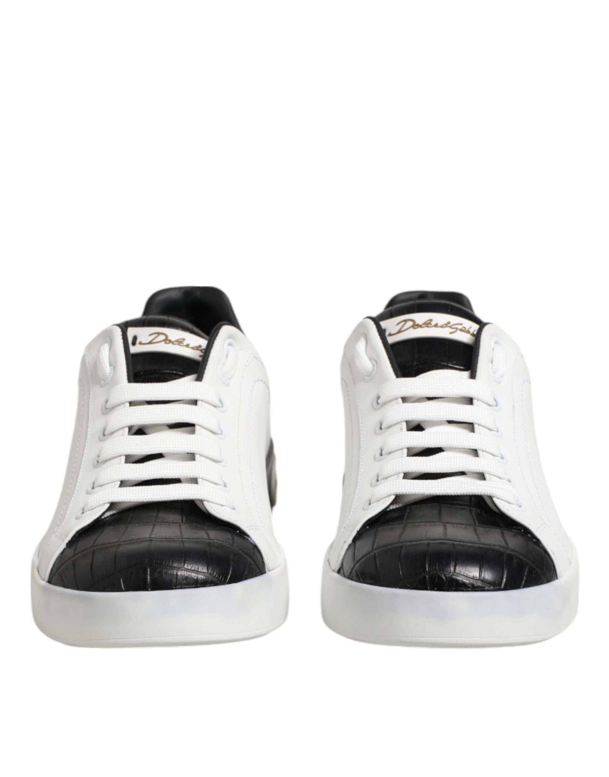 Pair of black and white leather sneakers with gold accents, featuring a crocodile skin texture on the side