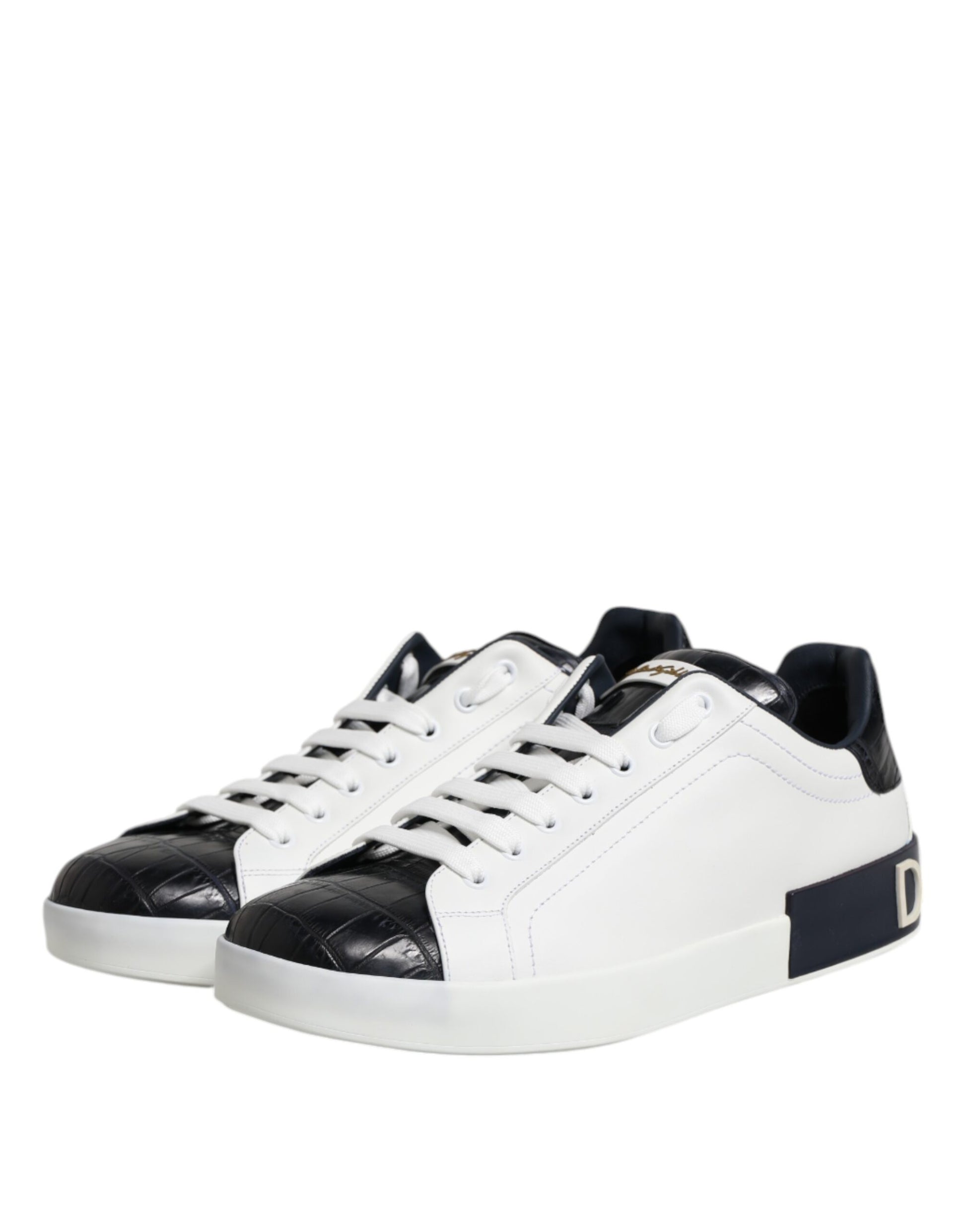 A pair of white black leather sneakers with a gold logo on the side, featuring a lace-up design and a chunky sole