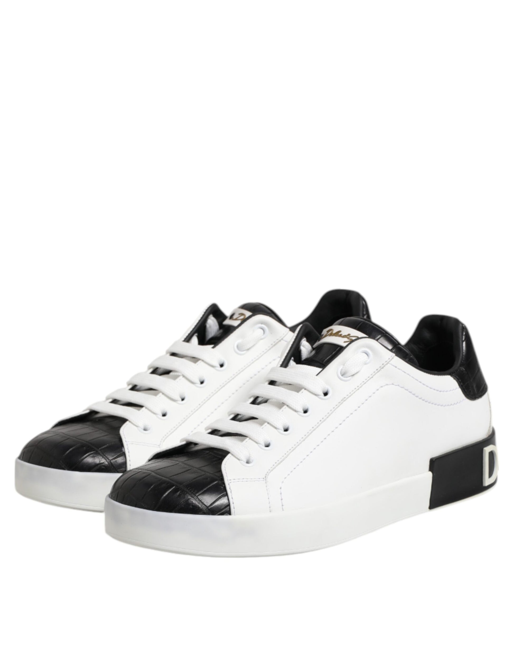 A pair of white black leather sneakers with gold accents, featuring a lace-up design and a chunky sole