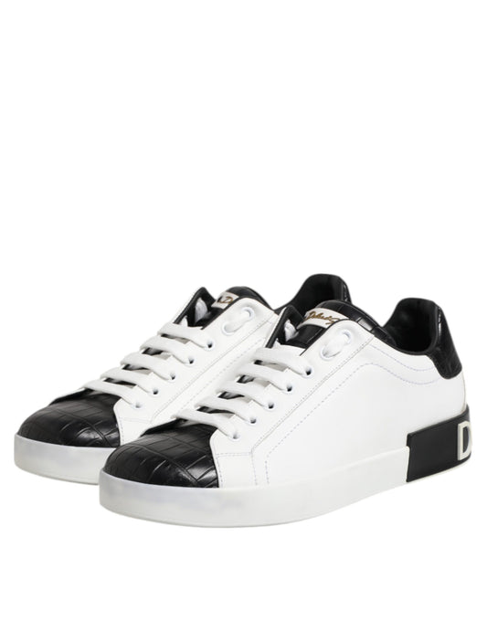A pair of white black leather sneakers with gold accents, featuring a lace-up design and a chunky sole