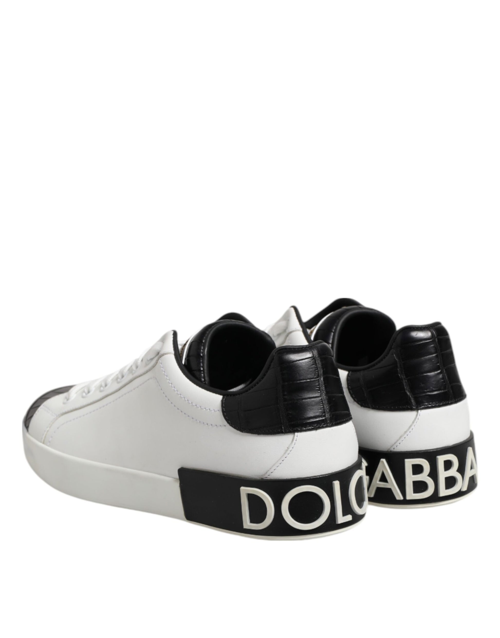 A pair of white black leather sneakers with a logo on the side, featuring a portofino design