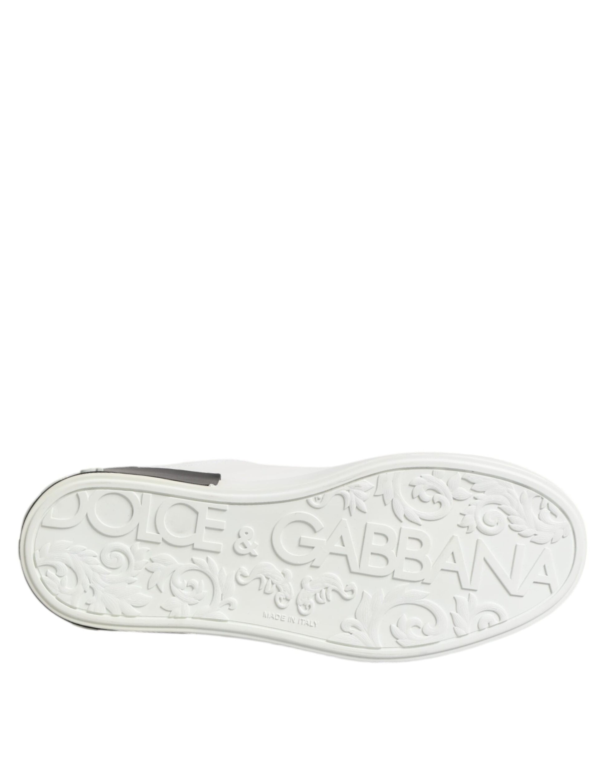A white black leather shoe with a gold buckle and the brand name "Dolce & Gabbana" on it