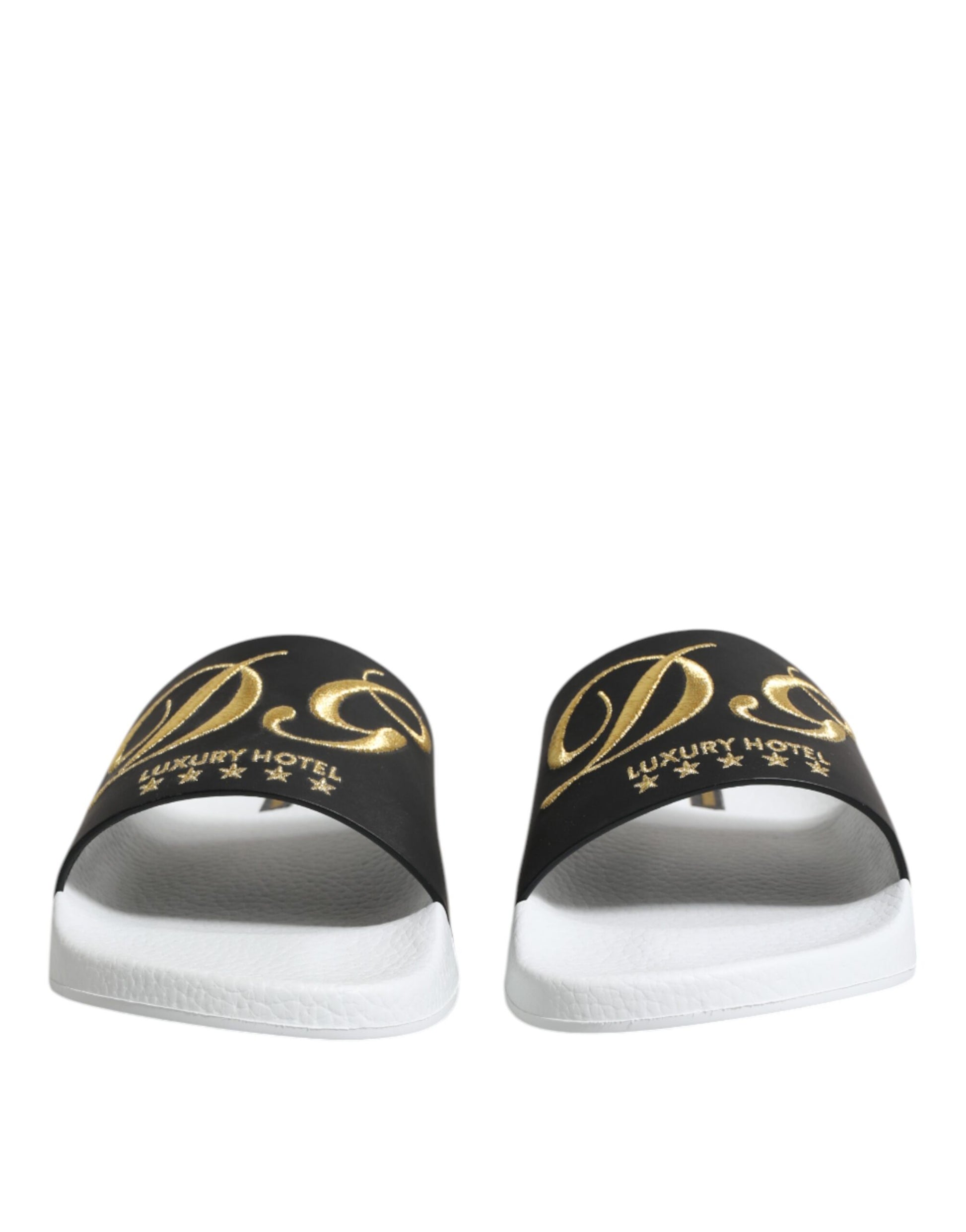 Pair of black and white flip flops with gold lettering