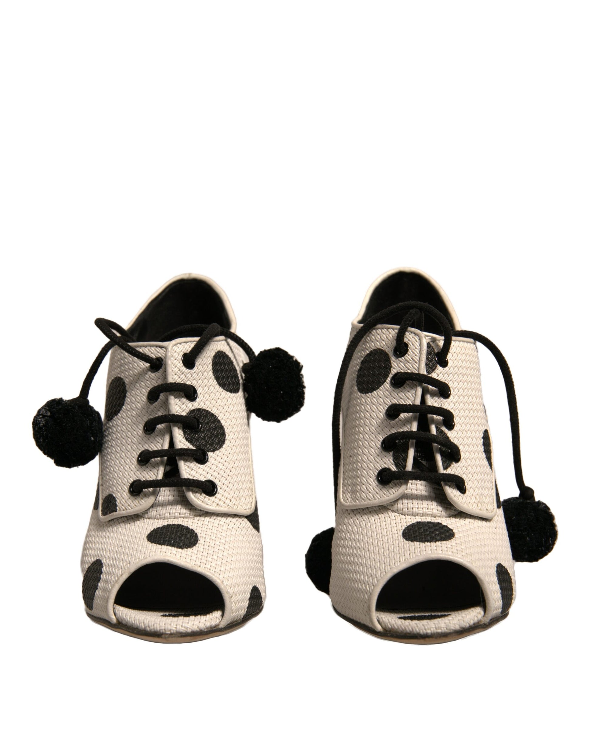 Pair of children's shoes with polka dots and pom poms on laces