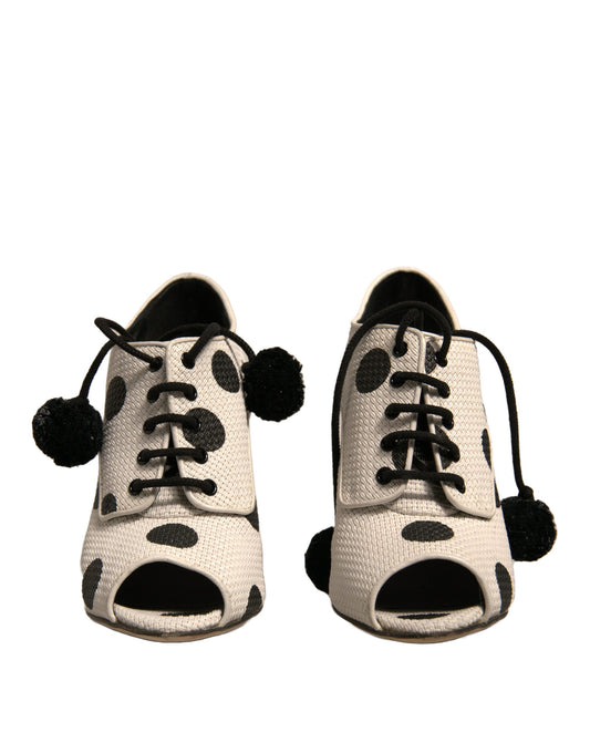 Pair of children's shoes with polka dots and pom poms on laces