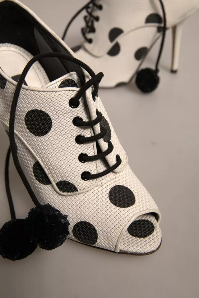 White polka dot shoes with black laces and a bow on top