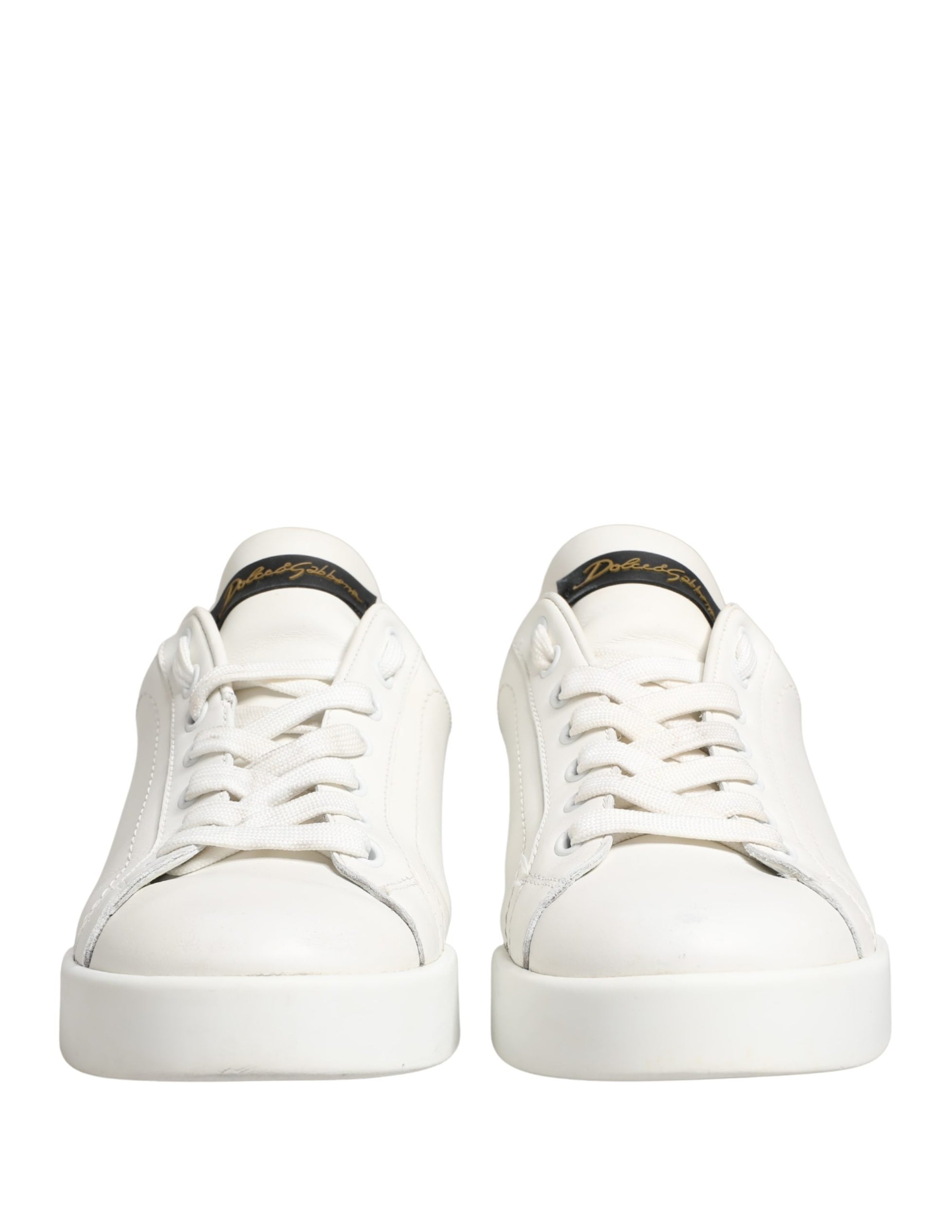 Pair of white sneakers with black accents and a gold logo on the side