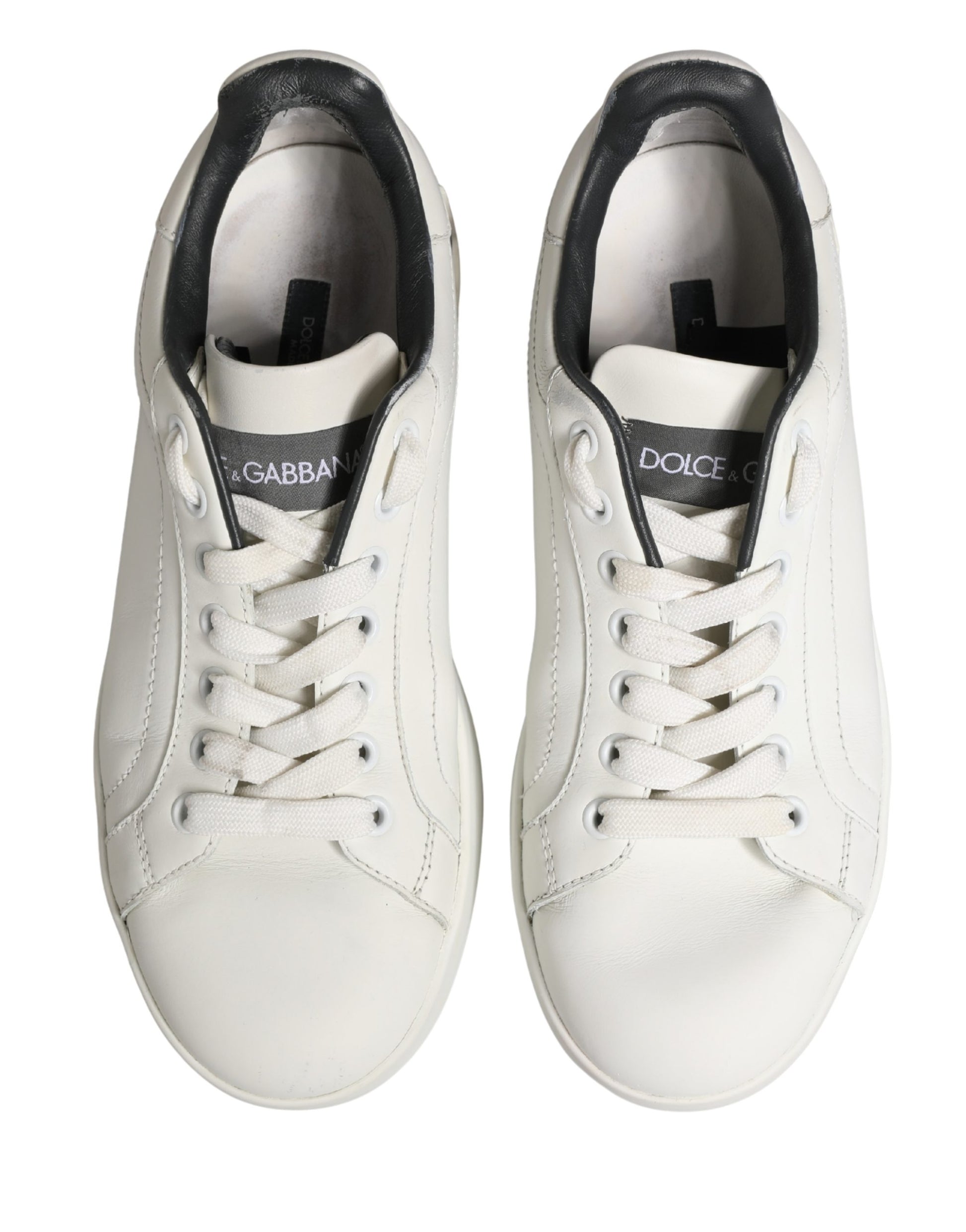 Pair of white leather sneakers with black laces and logo, featuring a low-top design