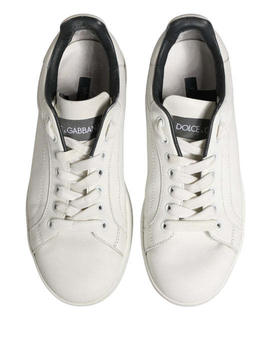 Pair of white leather sneakers with black laces and logo, featuring a low-top design