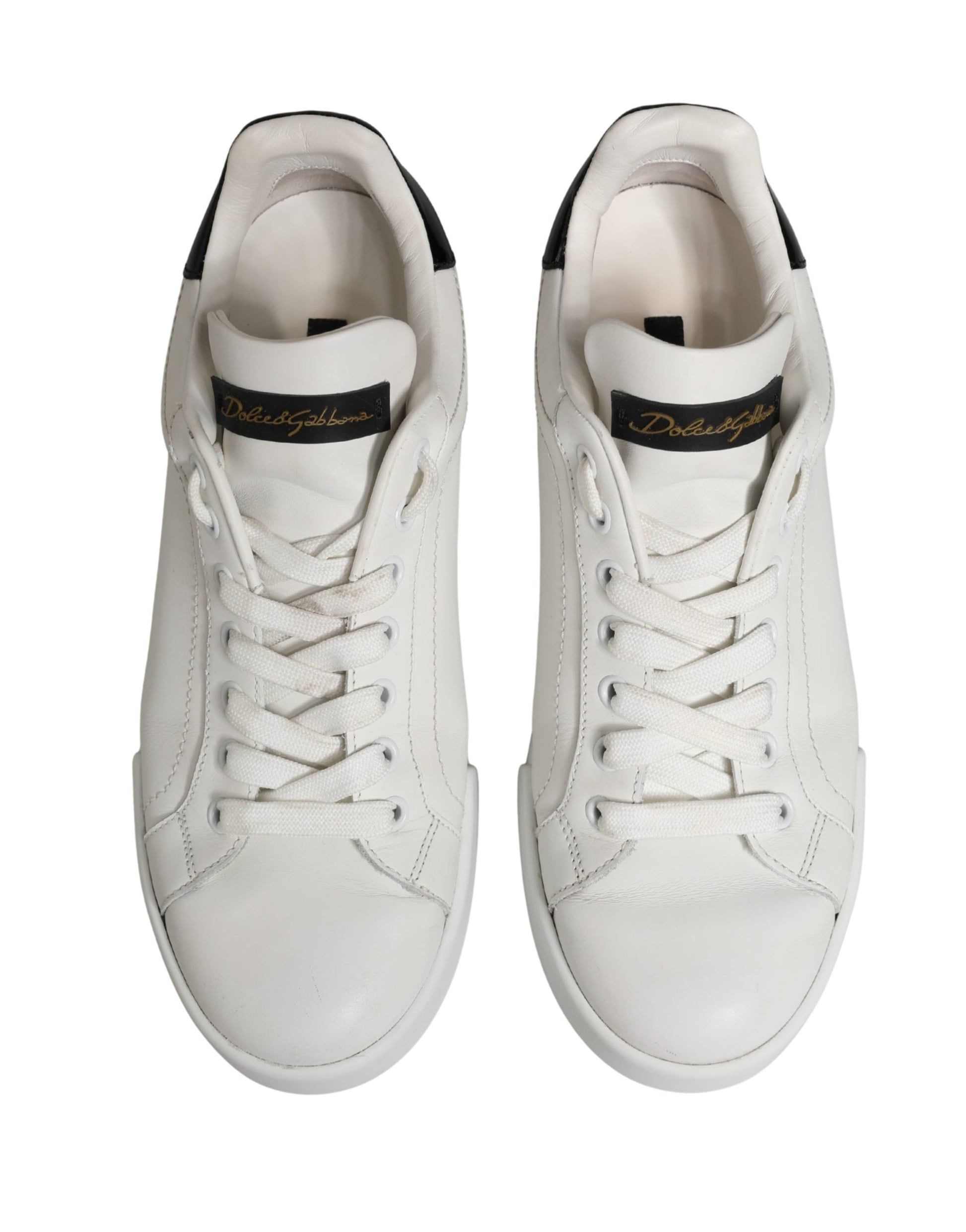 Pair of white leather sneakers with black accents, featuring a logo on the side