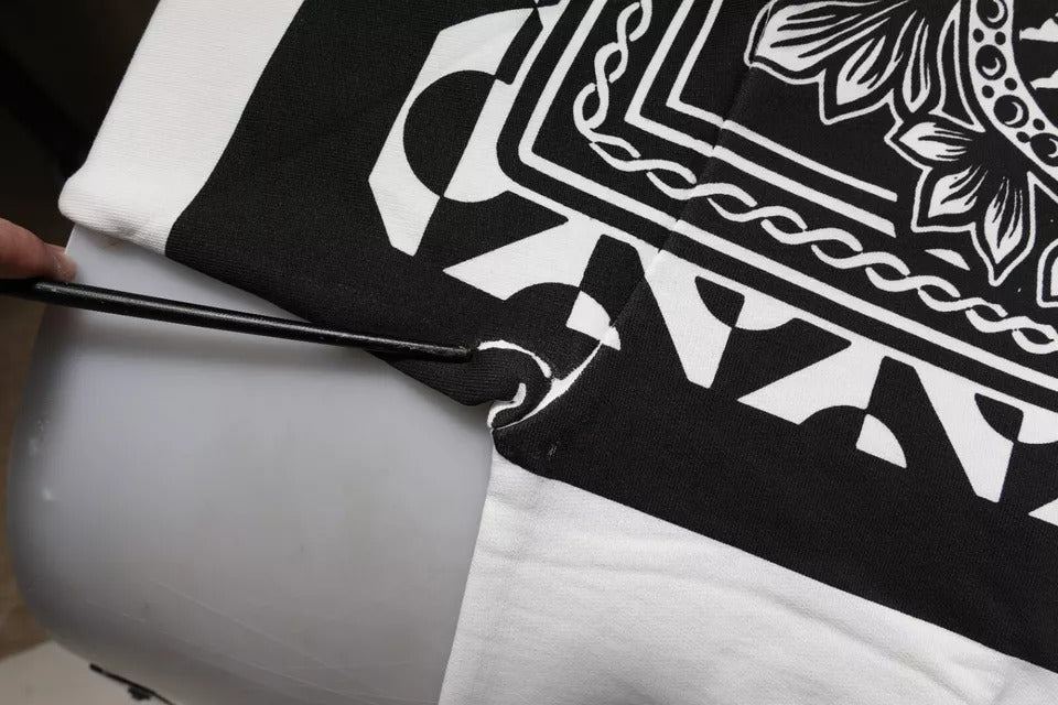 Towel with embroidered design being ironed by hand
