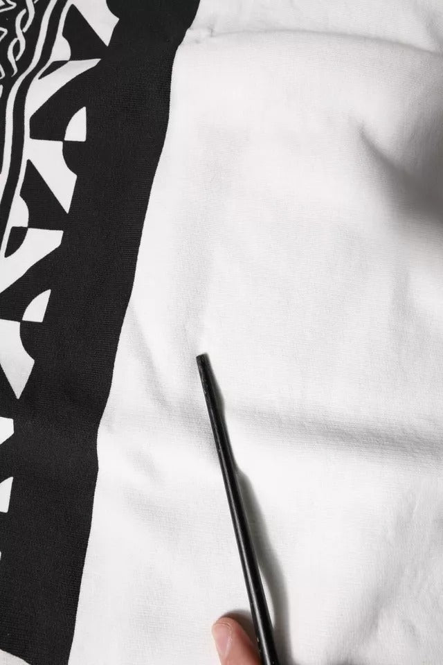 Hand holding a black pen over white paper