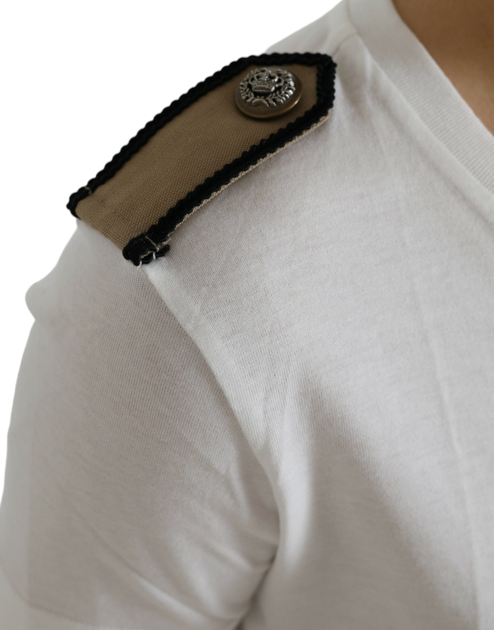 Tan shoulder strap with embroidered emblem on white shirt