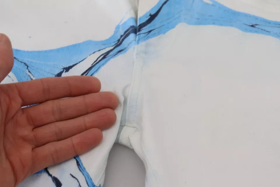 Hand holding a piece of clothing with blue and white design
