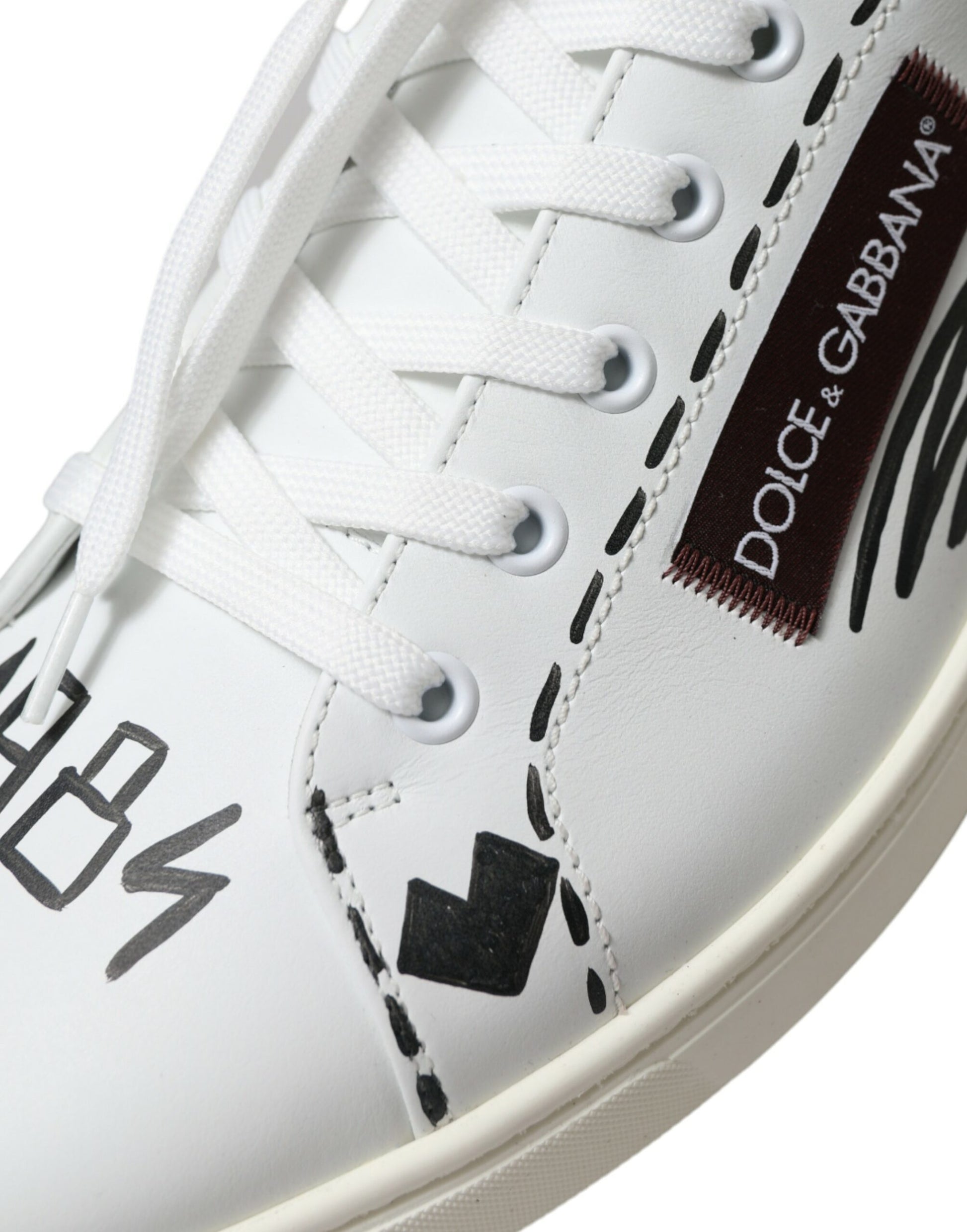 White sneaker with black and white laces, brand logo on side, and black writing on side