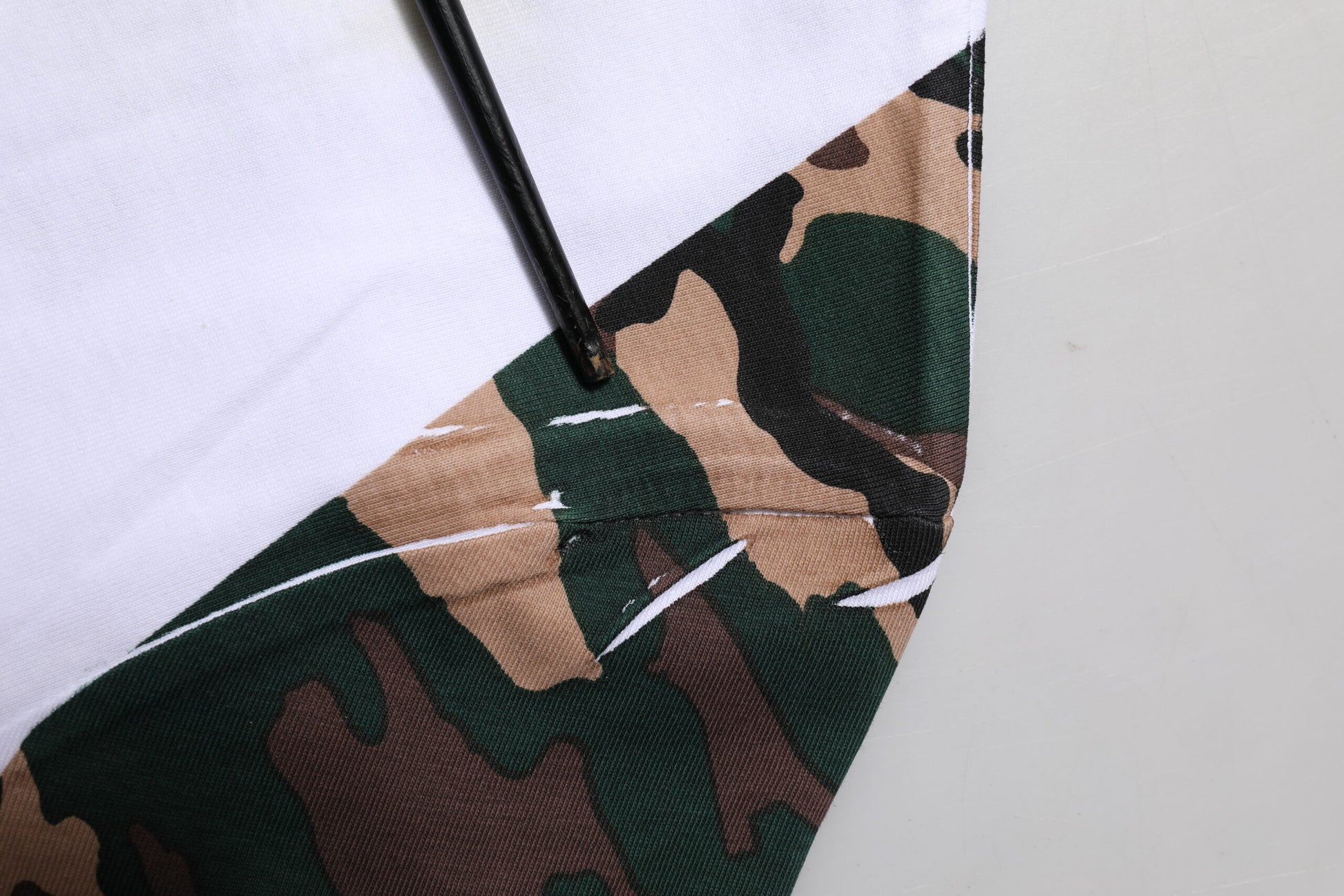 Camouflage fabric with white stitching