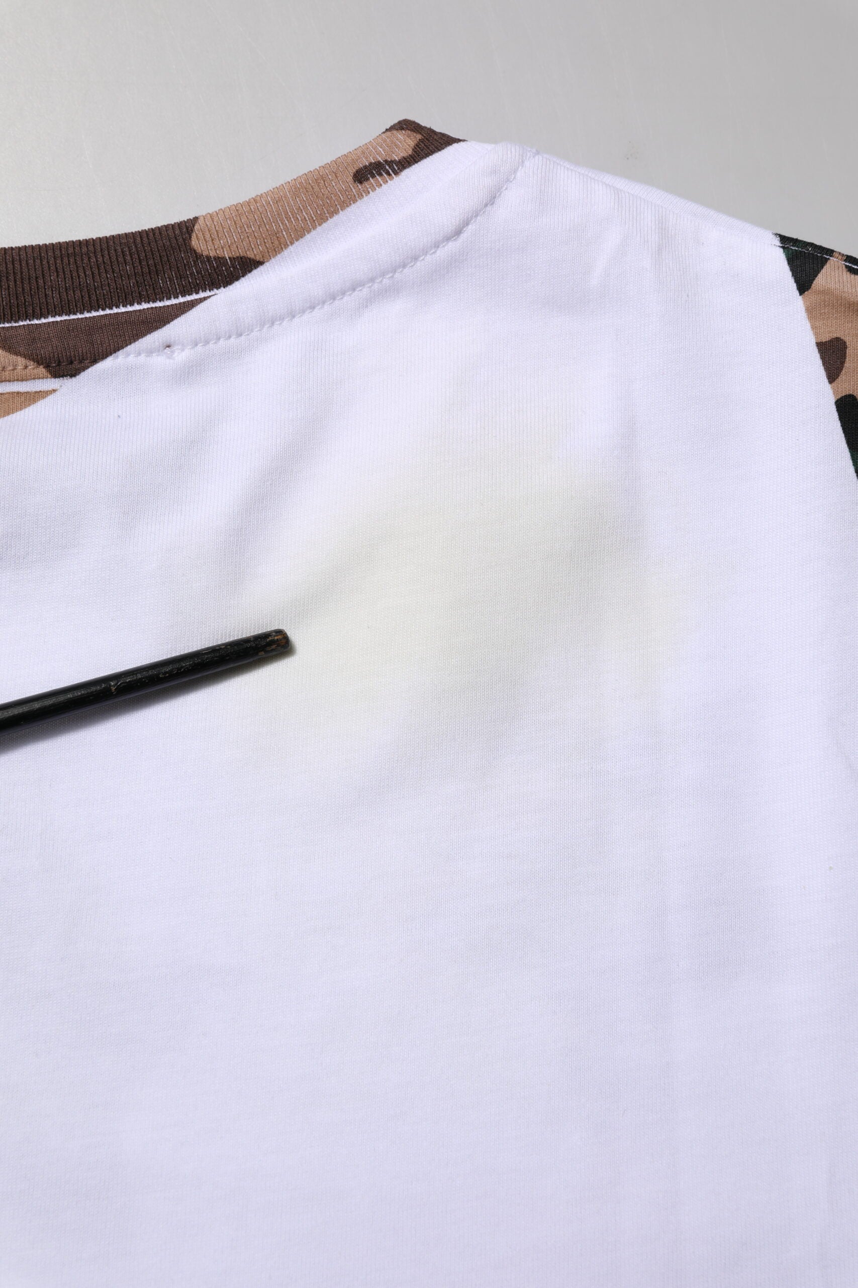 White t-shirt with yellow stain on front
