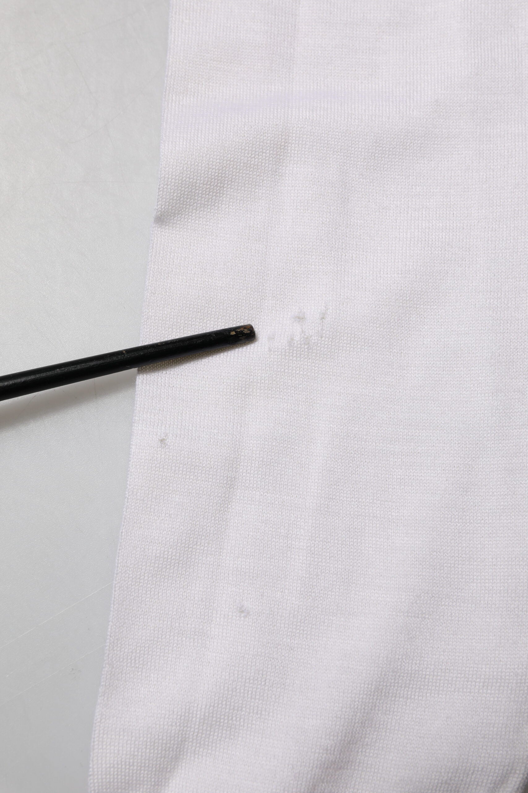 Black pin in white fabric