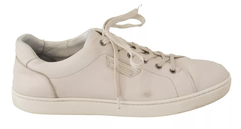 Pair of white leather sneakers with laces and logo on side