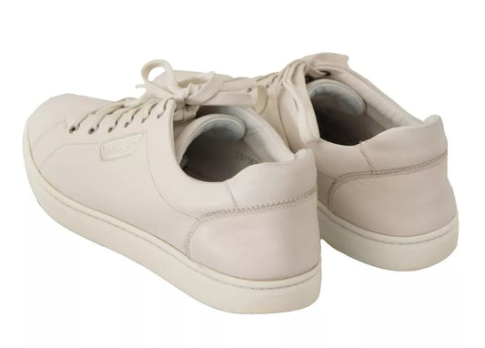 Pair of white leather sneakers with logo on side, laces and rubber sole