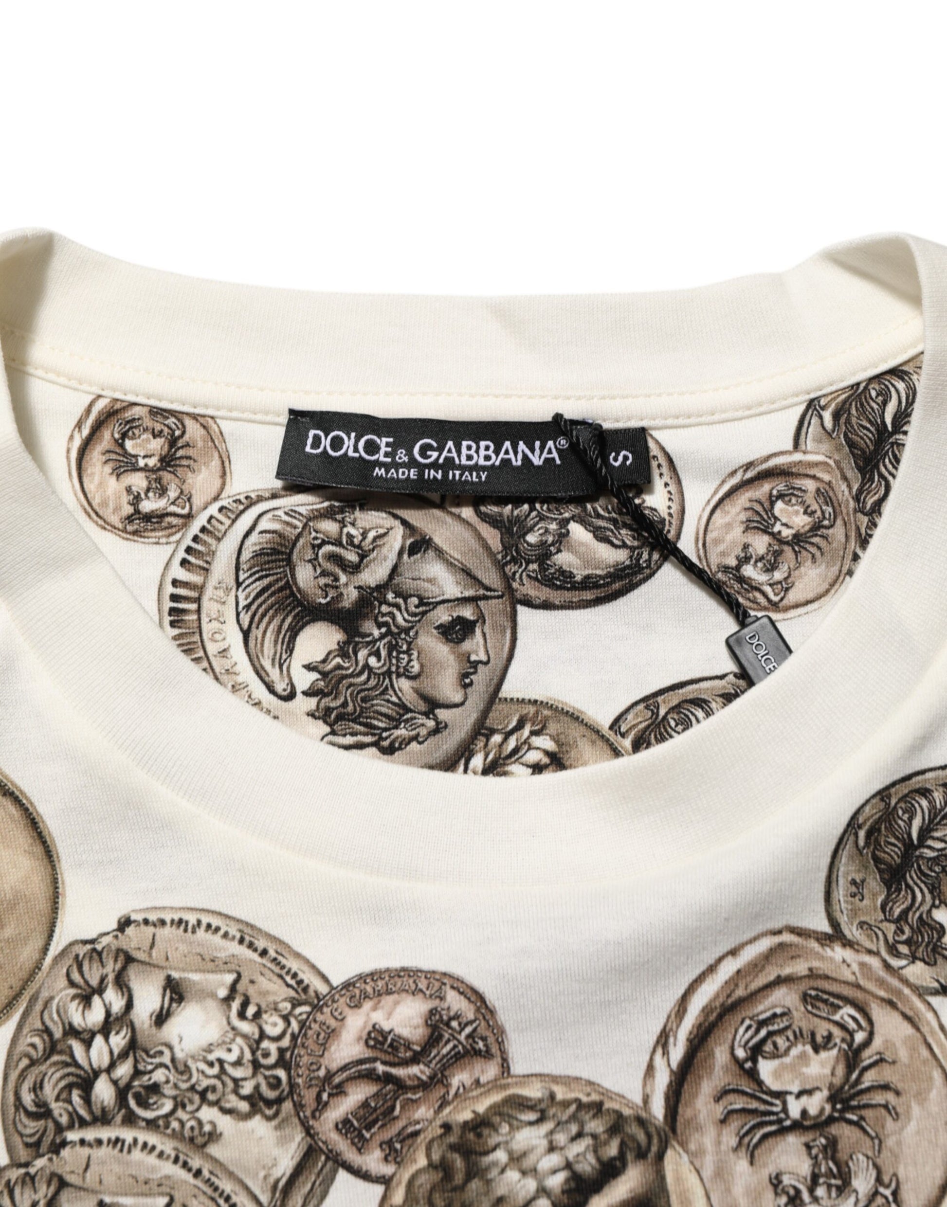 A beige sweater with a pattern of coins on it