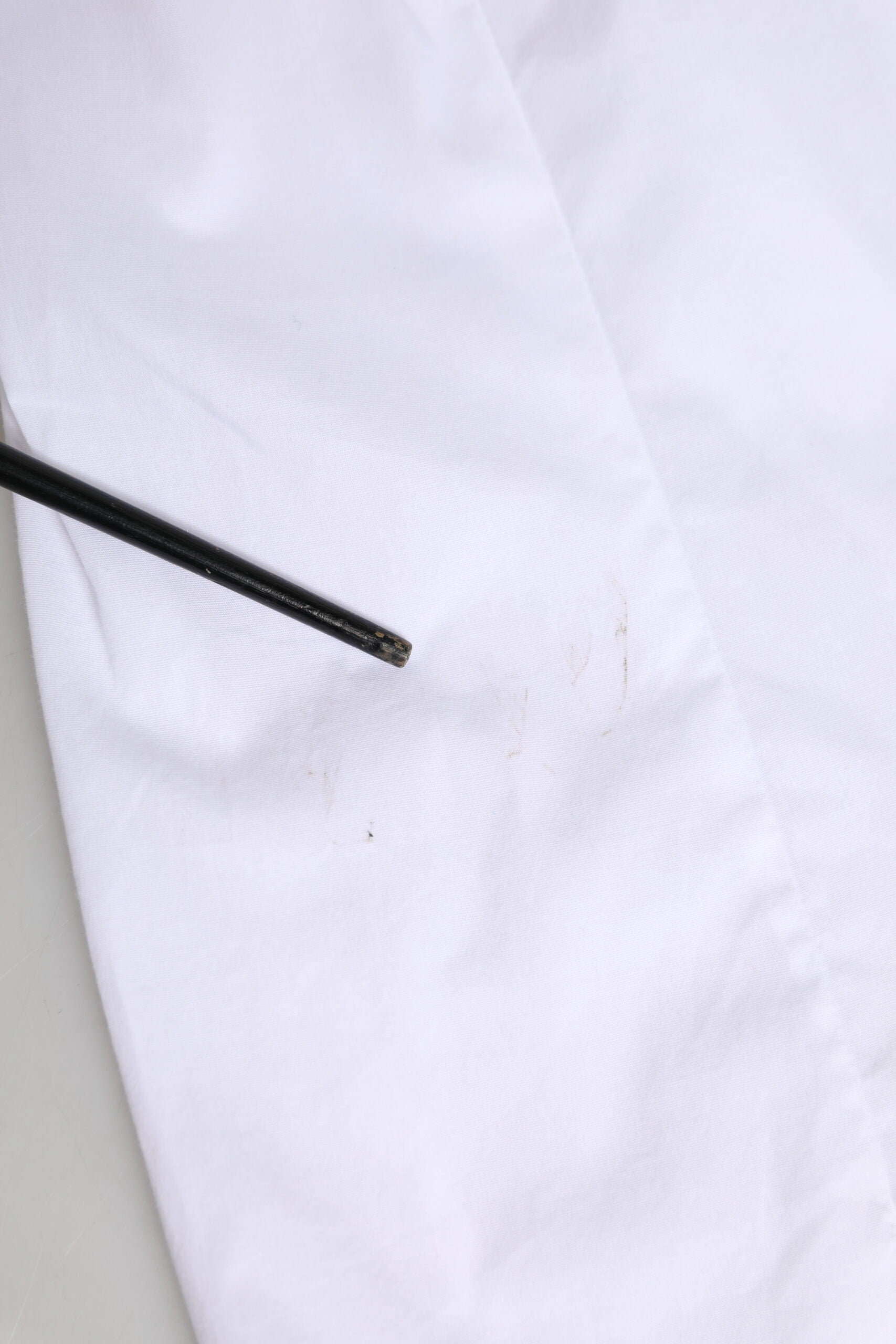 A white collared long sleeve dress shirt top with a black button