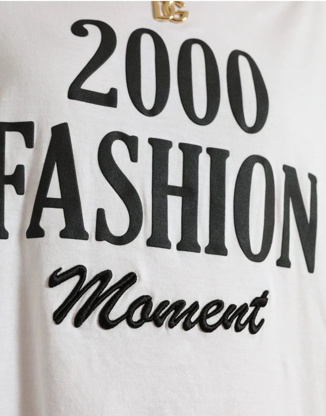 White t-shirt with black lettering reading "2000 fashion moment"