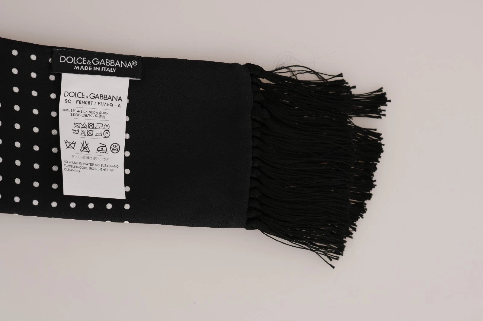 Black fabric with white dots and fringe ends