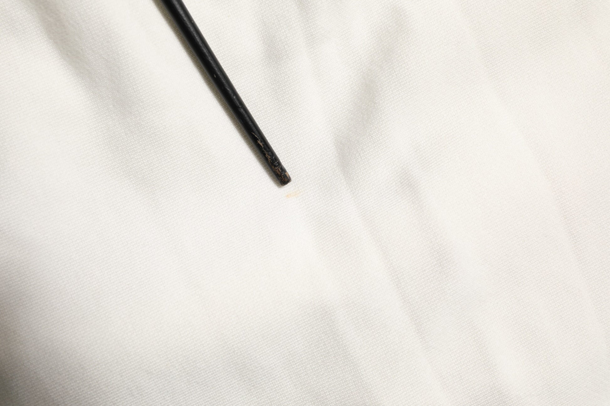 Black eyeliner pencil on white fabric