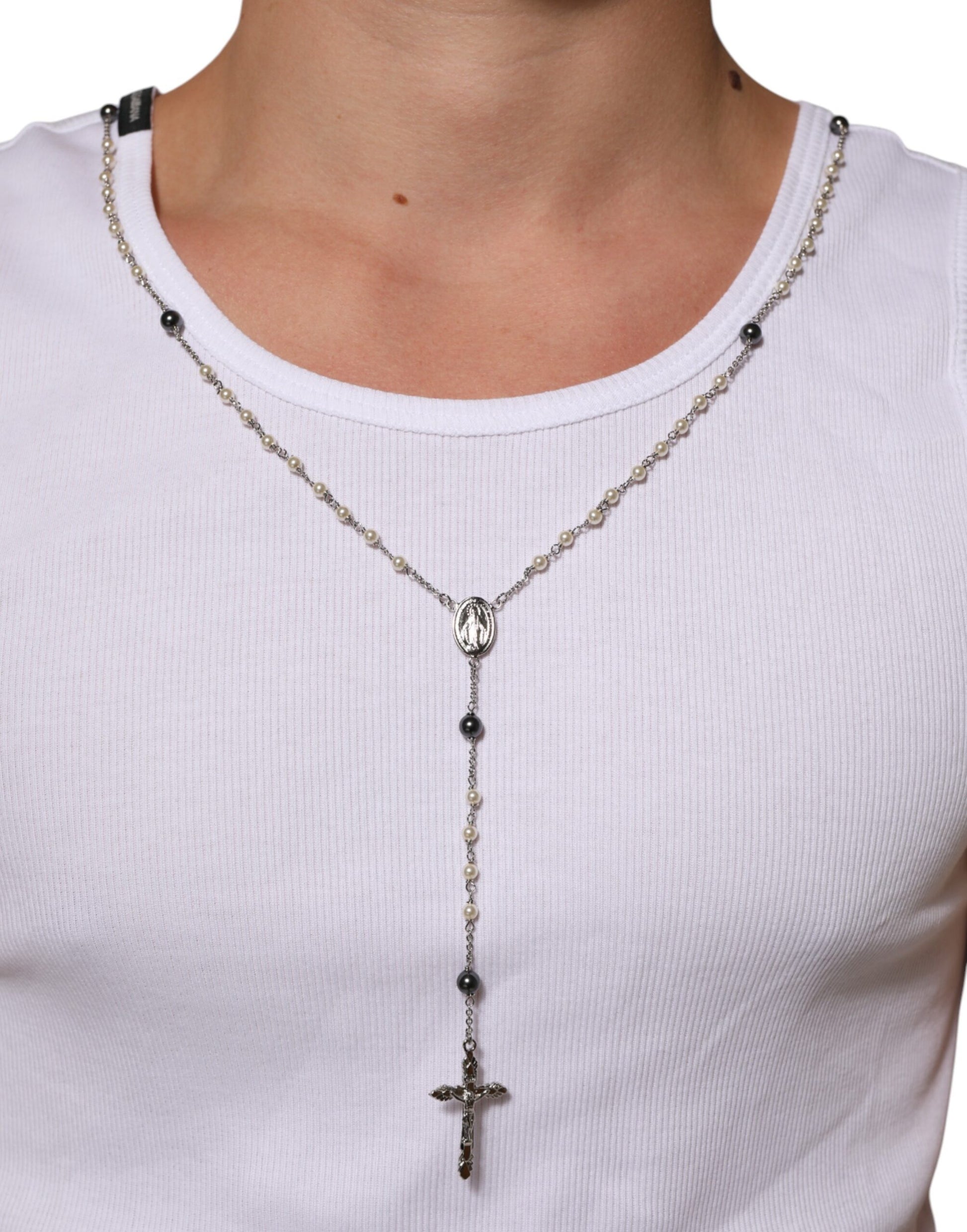Silver cross necklace on white shirt