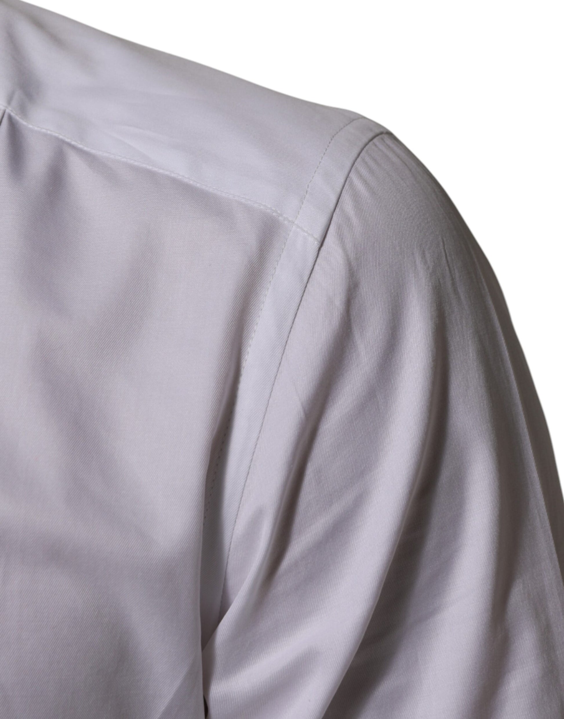 A close-up of a white cotton collared bib shirt with gold accents
