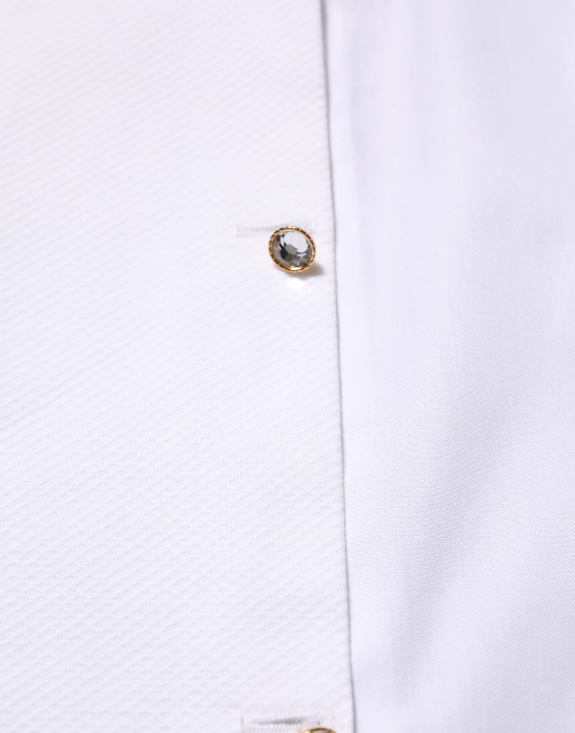 Gold button on white shirt