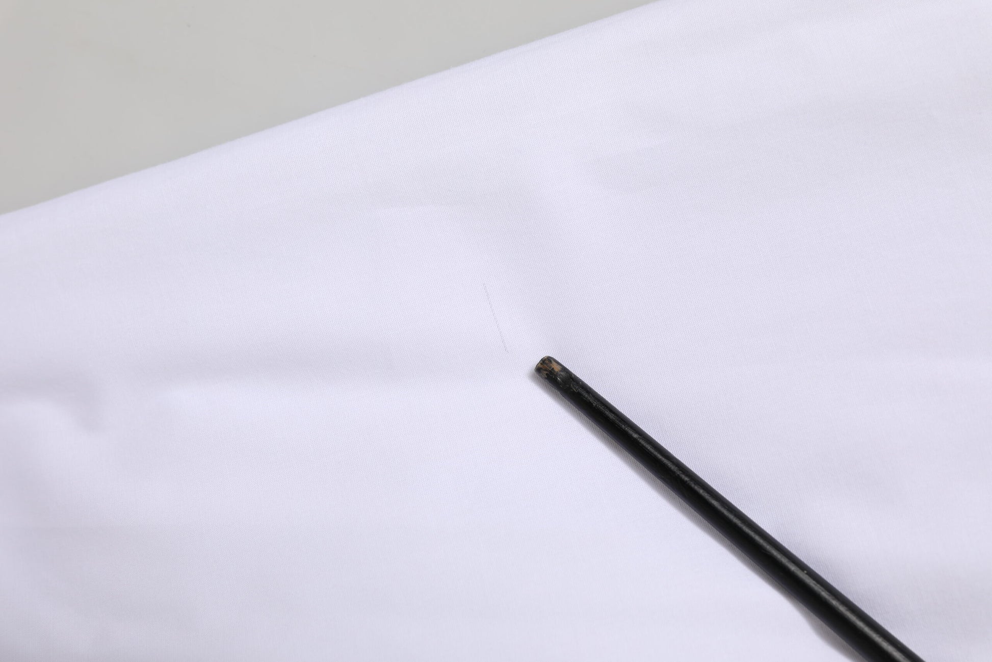 Black dress shirt with collar, sleeves and buttons on white fabric background