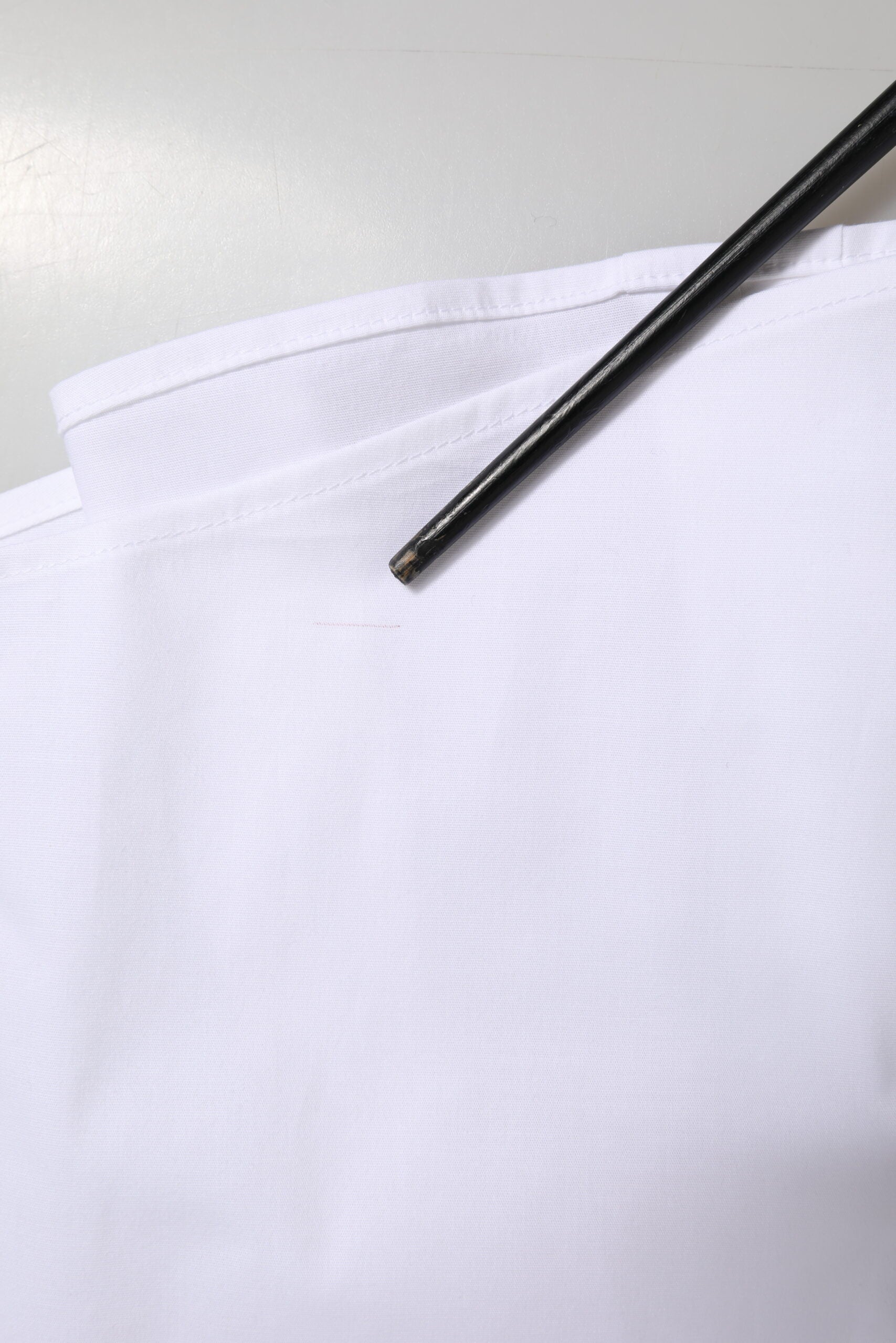 A white cotton collared dress shirt with a black tie