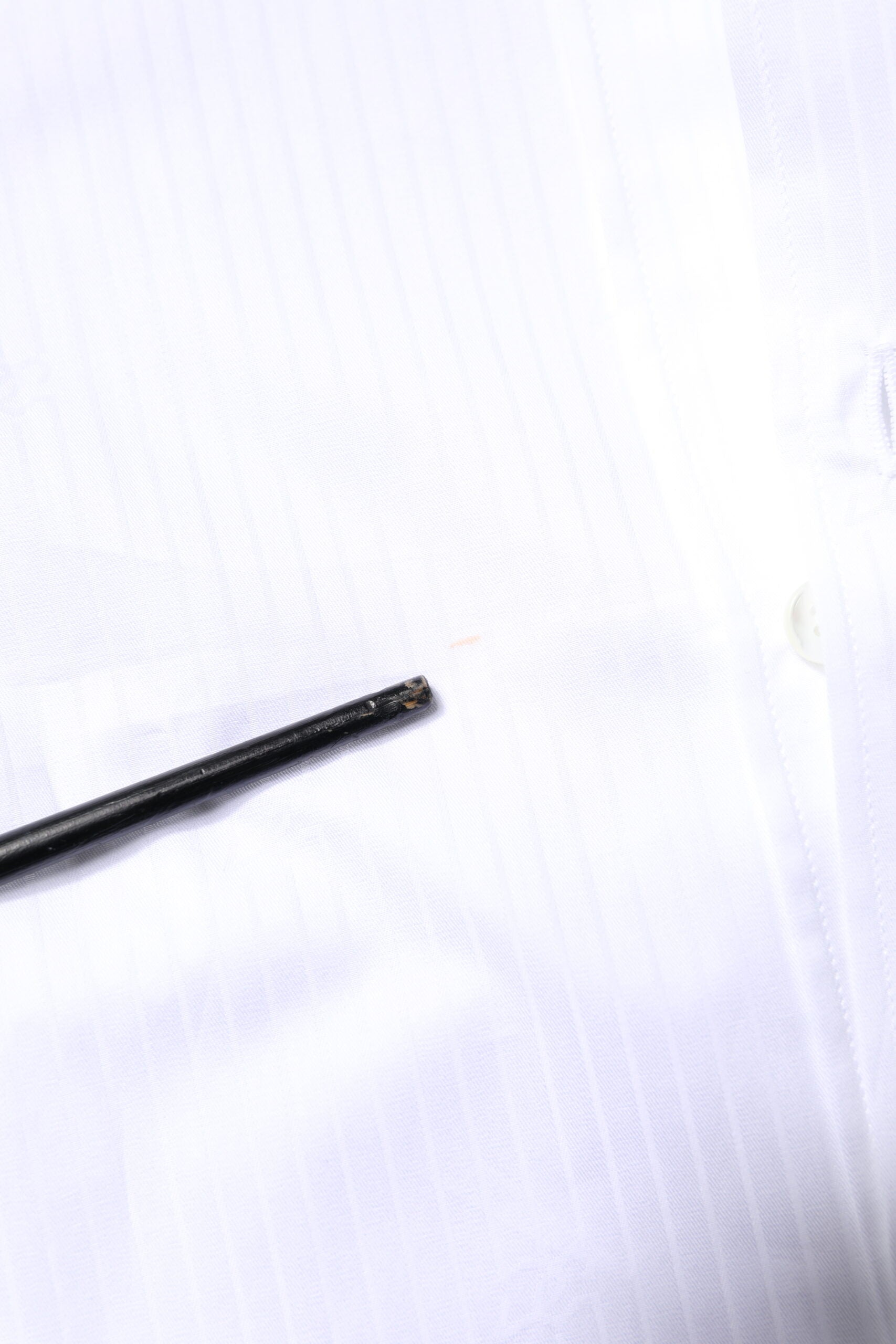 A black pin on a white shirt